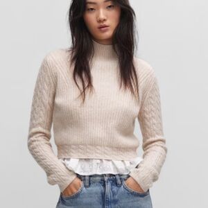 Thick knitted fabric. Braided details. Straight design. Crop design. Perkins col